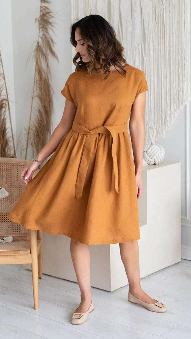 Woman wearing mustard linen dress front view