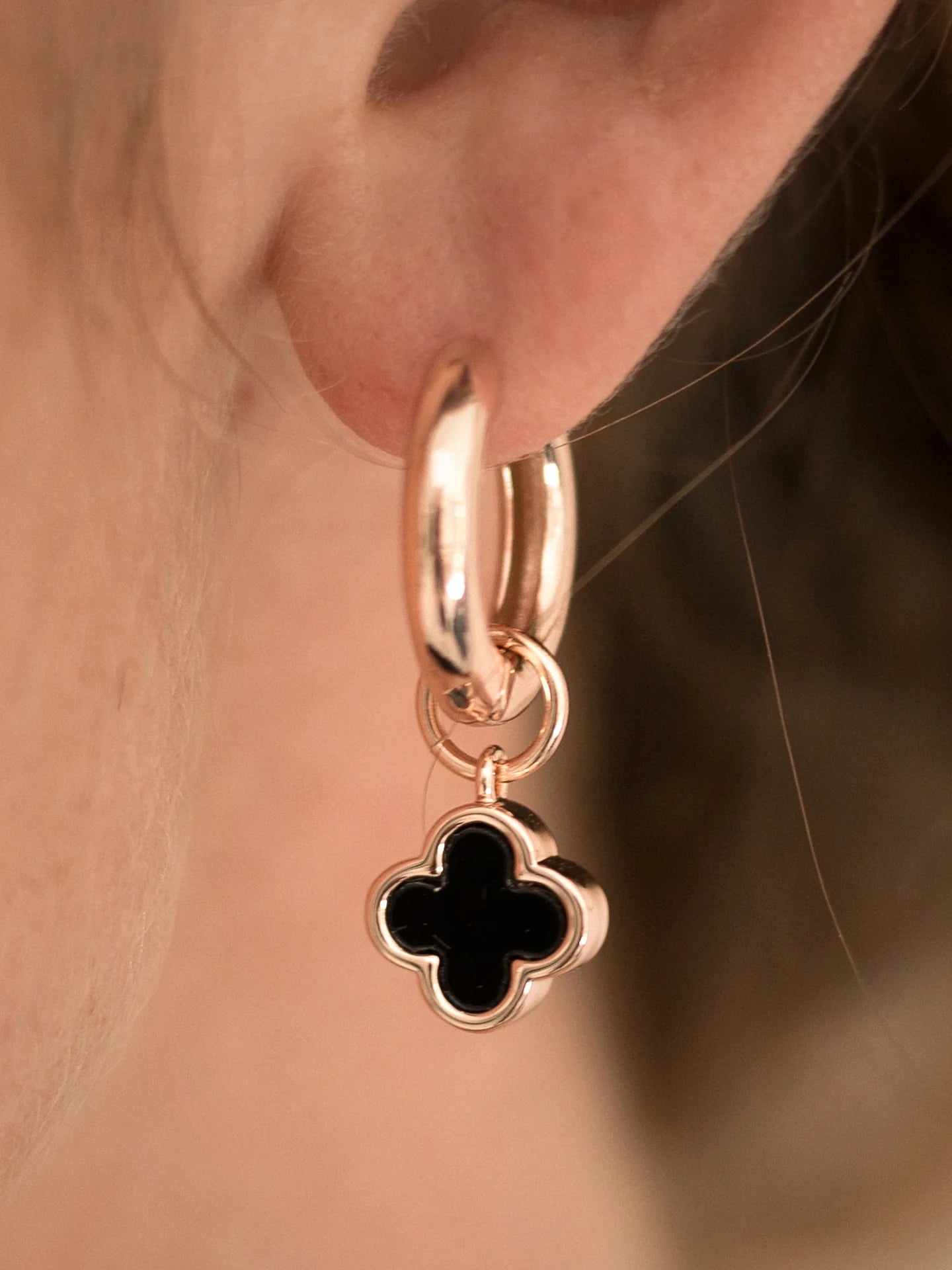 woman wearing rose gold flower earring