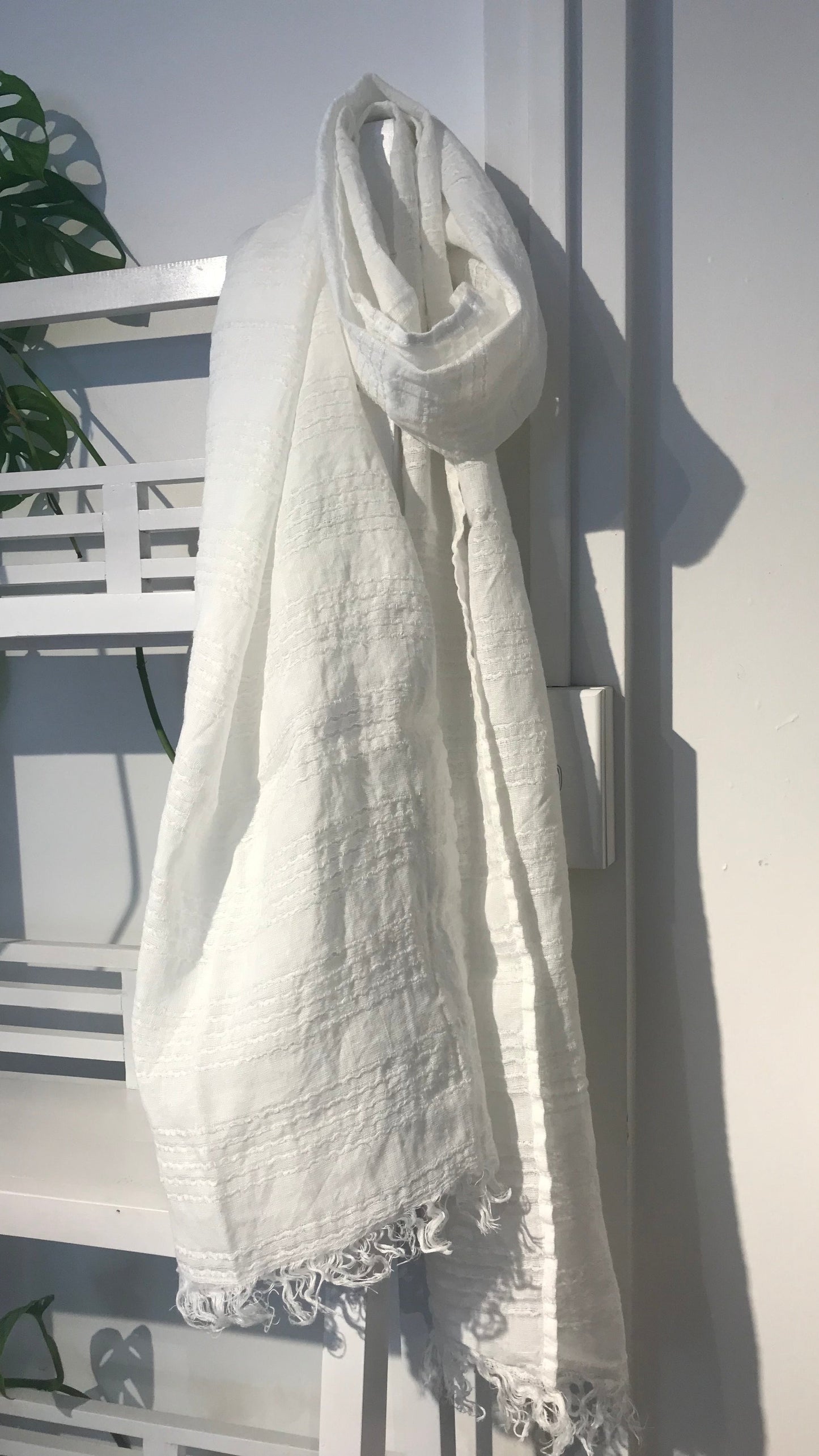Linen scarf white stripe hanging on wooden shelf
