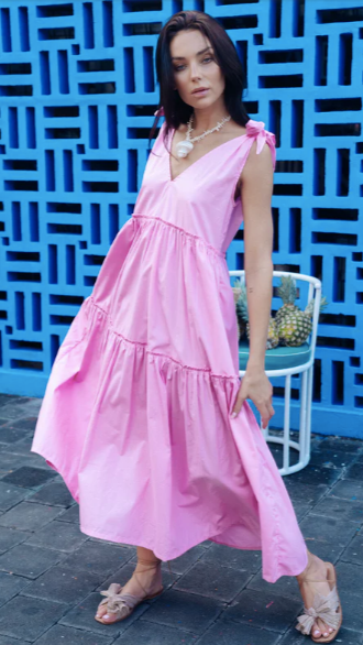Model wearing pink tiered poplin dress with tie shoulders