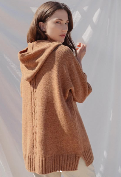 Back view of hooded cardigna in rust with cable back detail.