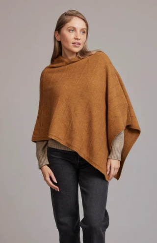 Woman wearing a Merino and possum poncho featuring a diagonal garter stitch.