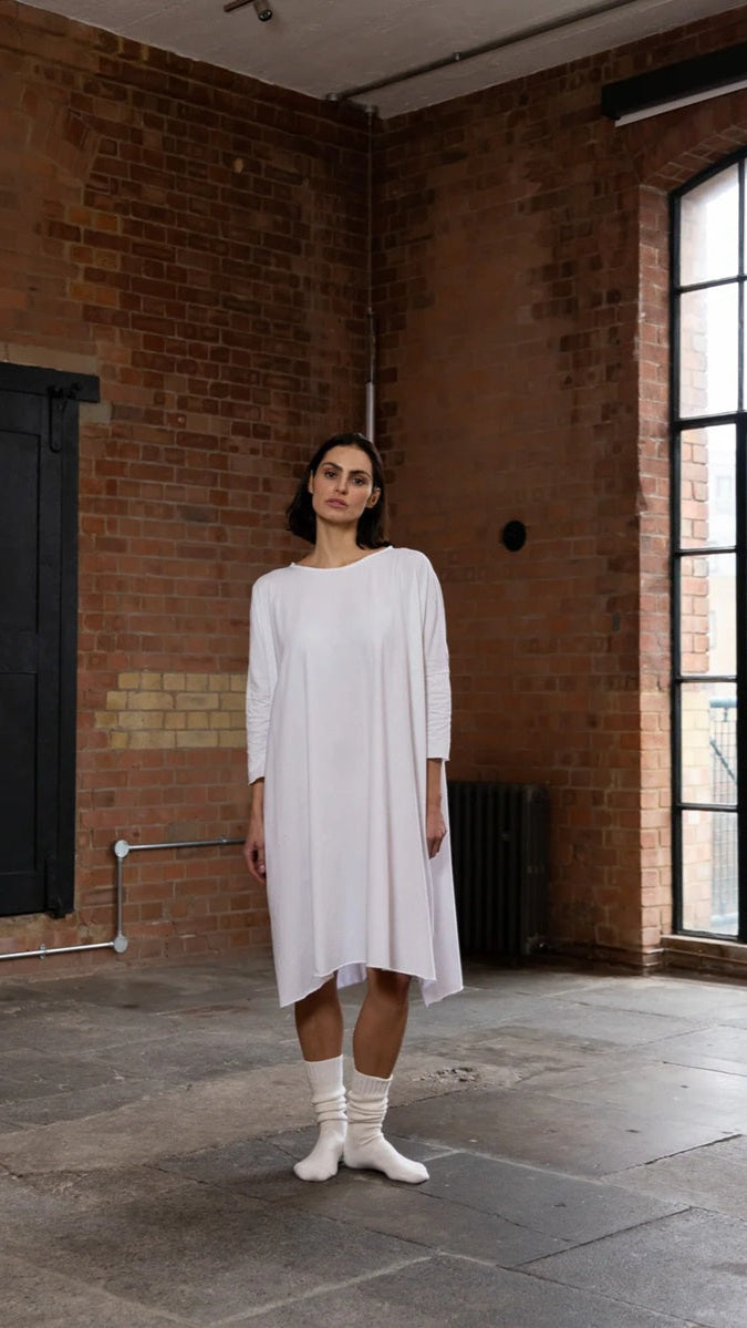 Woman wearing long flowing white t shirt dress