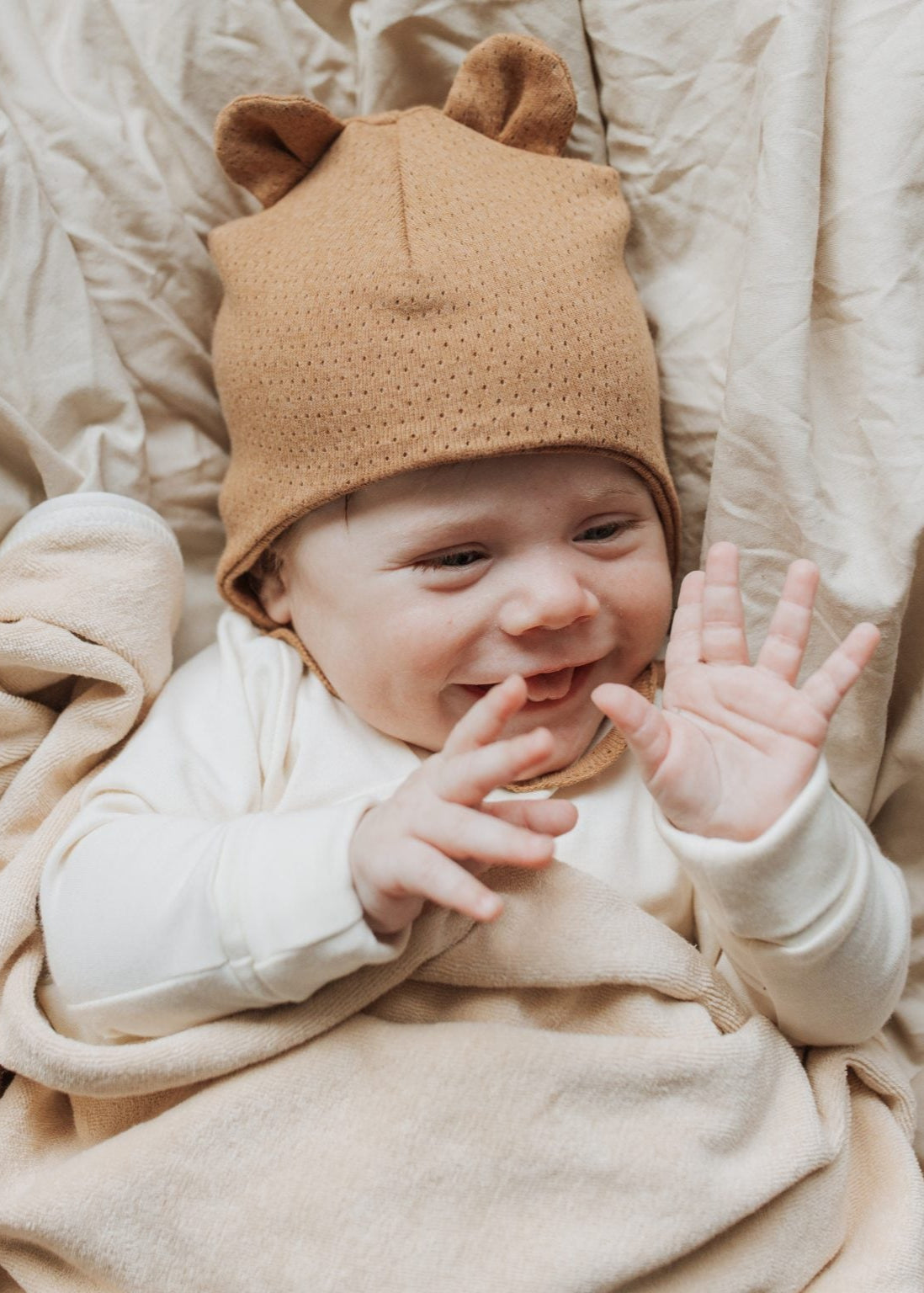 Baby wearing dark brown baby hat with ears.