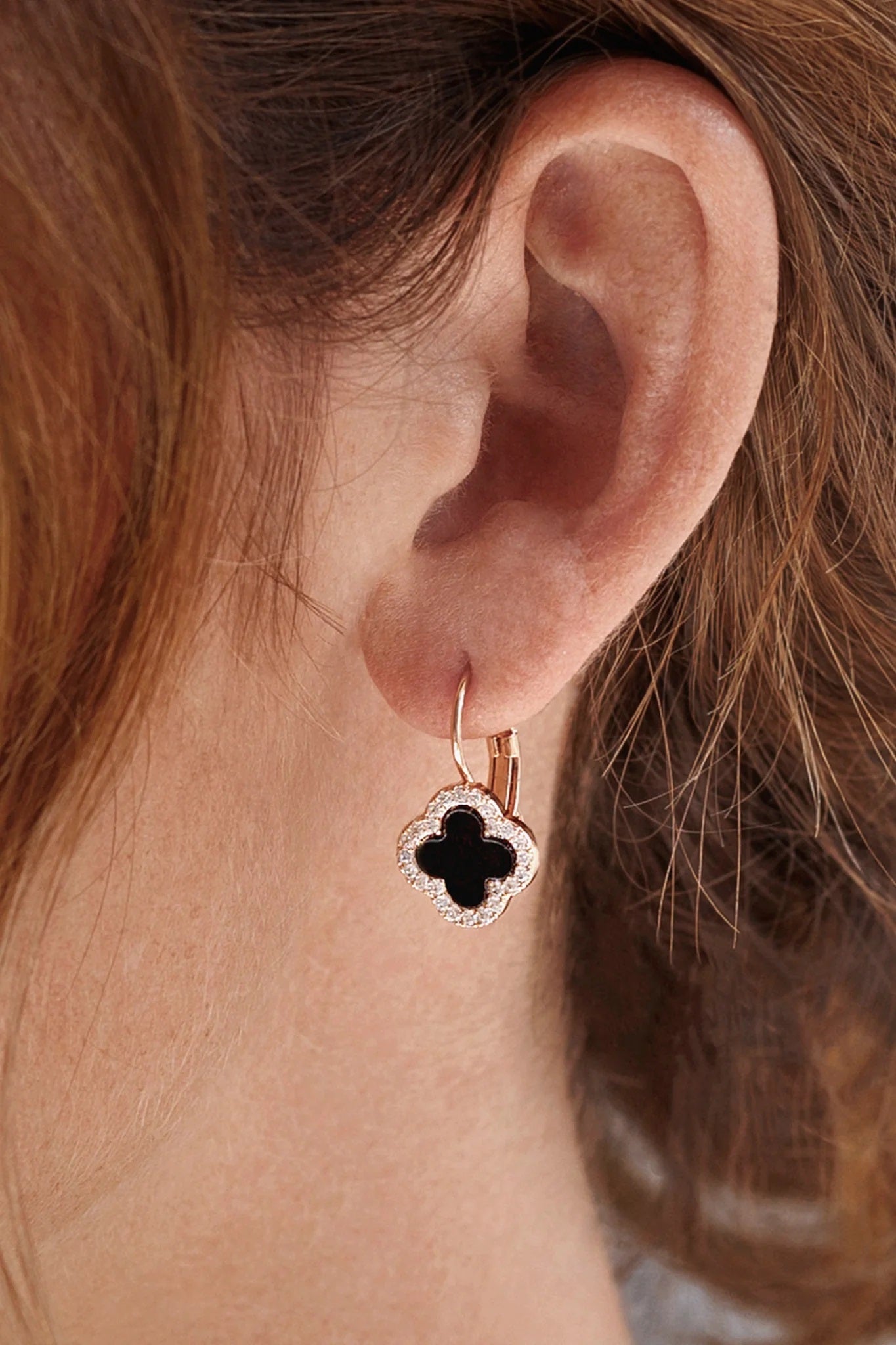 Model wearing black star earrings