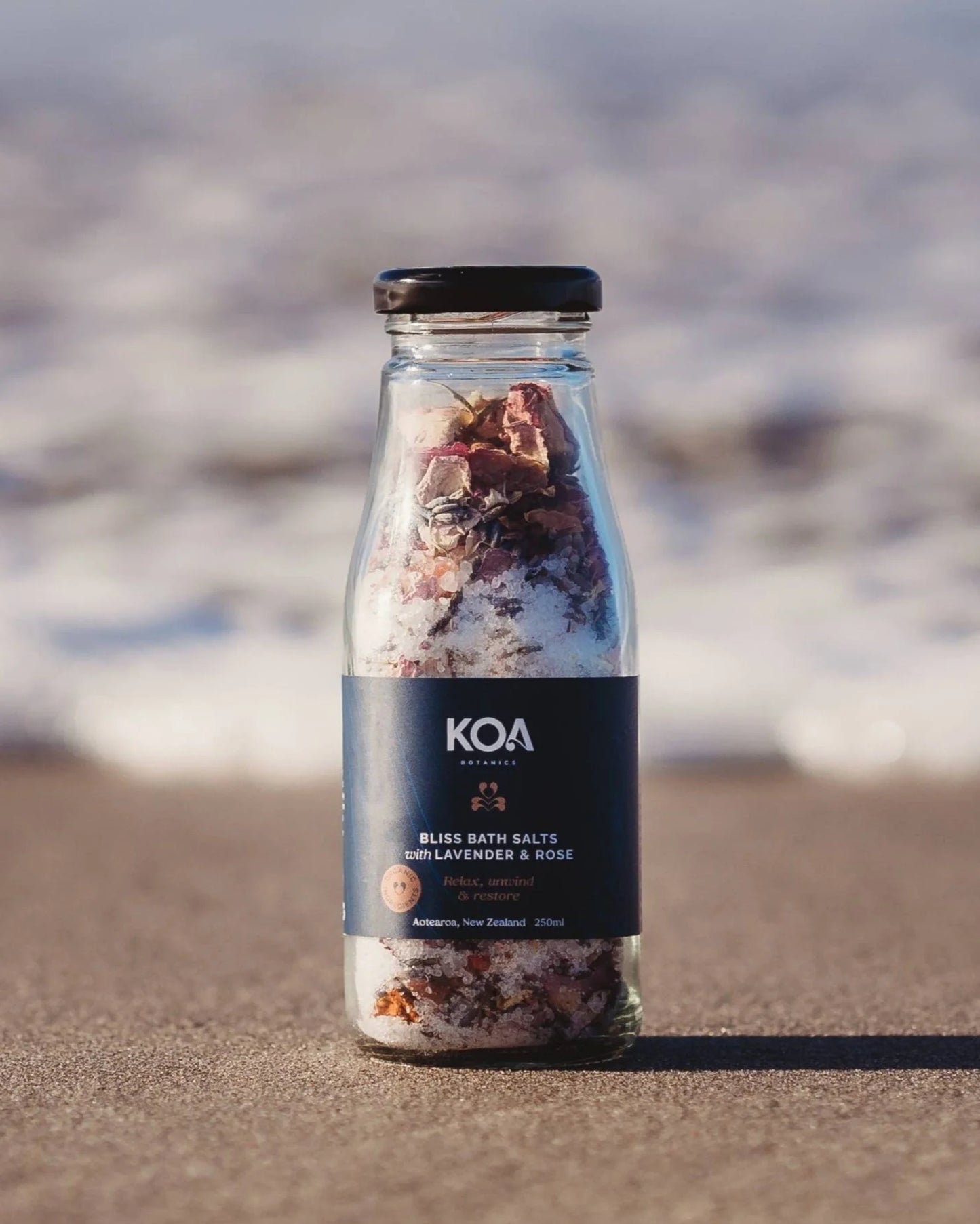 Glass Bottle Bliss Bath Salts with Lavender & Rose on the beach.