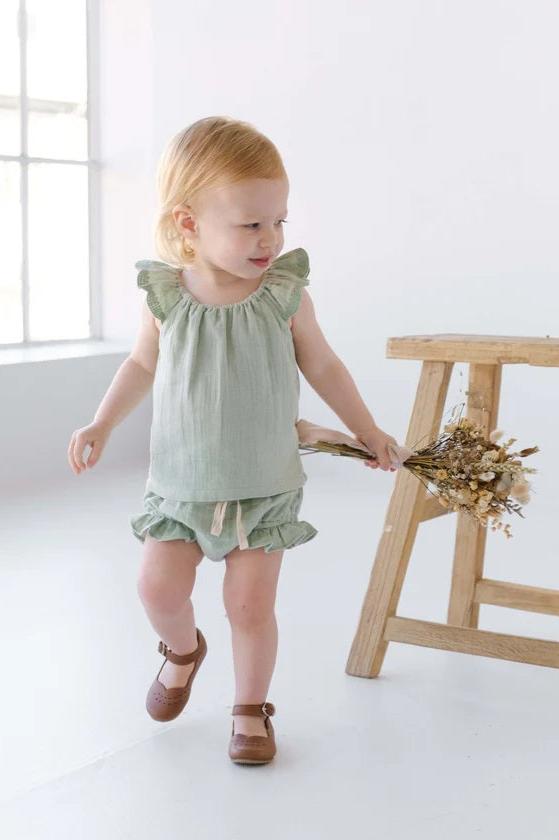 Toddler wearing sage green blouse and bloomer