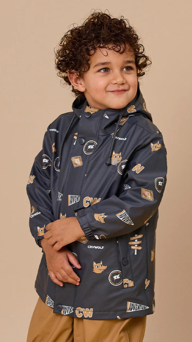 Young boy wearing charcoal adventure playjacket with wolf pattern.