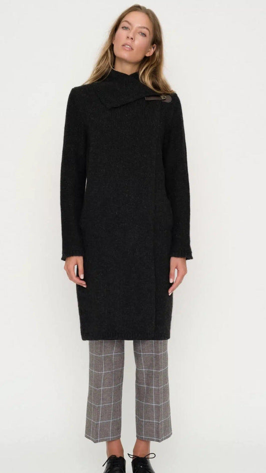 Woman wearing black wool coat with buckle and stand up collar