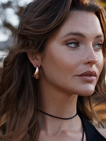 Lady wearing rose gold cosmic drop earrings.