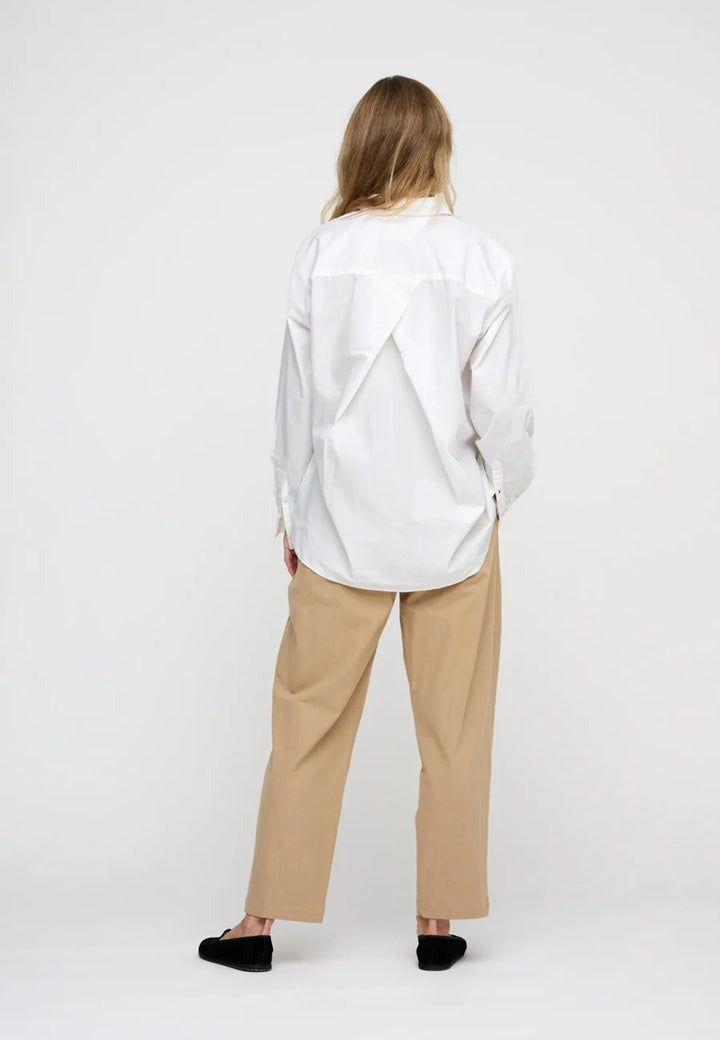 Woman wearing white poplin shirt with back pleat detail