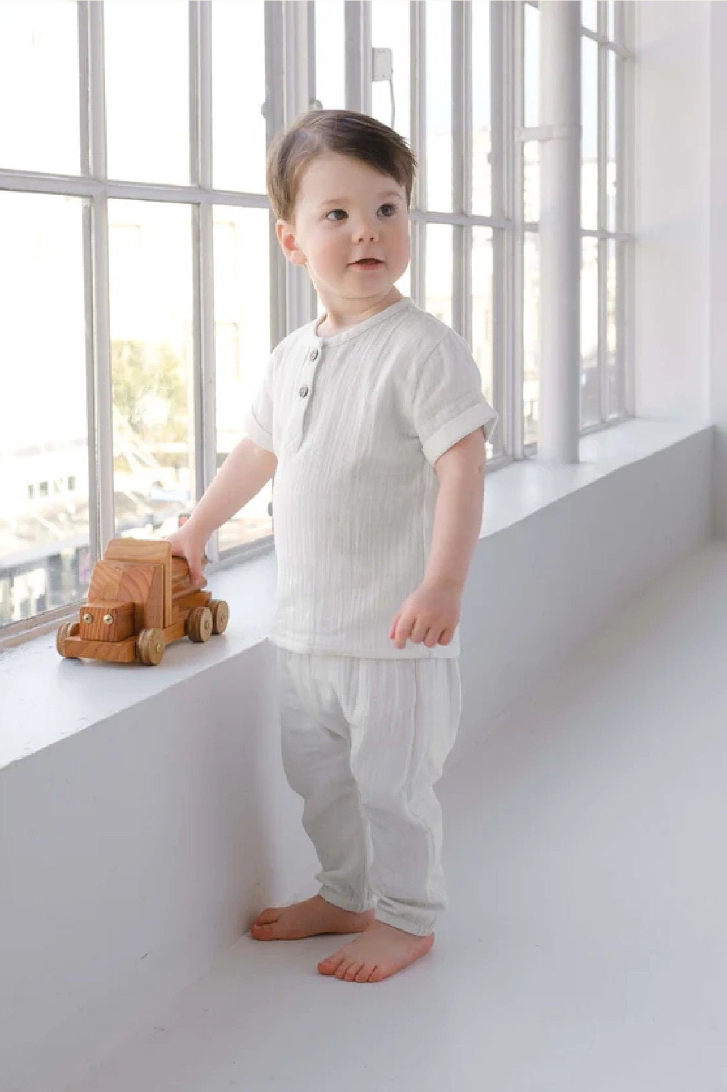 Toddler wearing muslin top with muslin drawstring pant in white