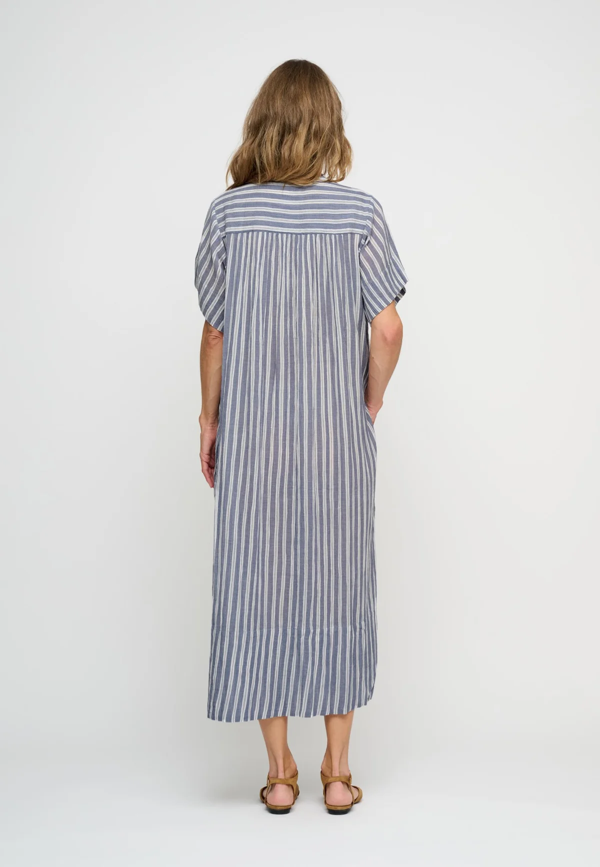 Woman wearing short sleeve blue stripe shirt dress back view.