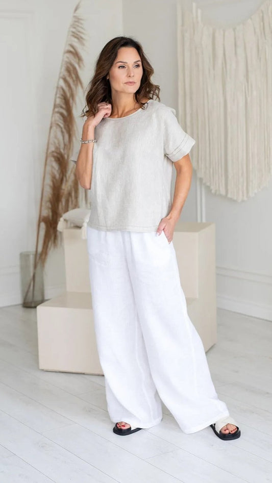 Woman standing wearing white relaxed trouser