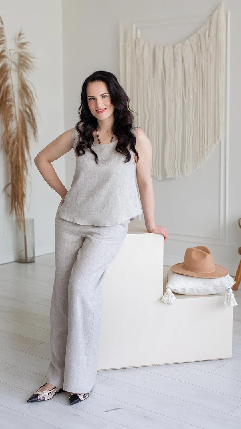 Woman wearing natural linen sleeveless top and pants in a bright, minimal room