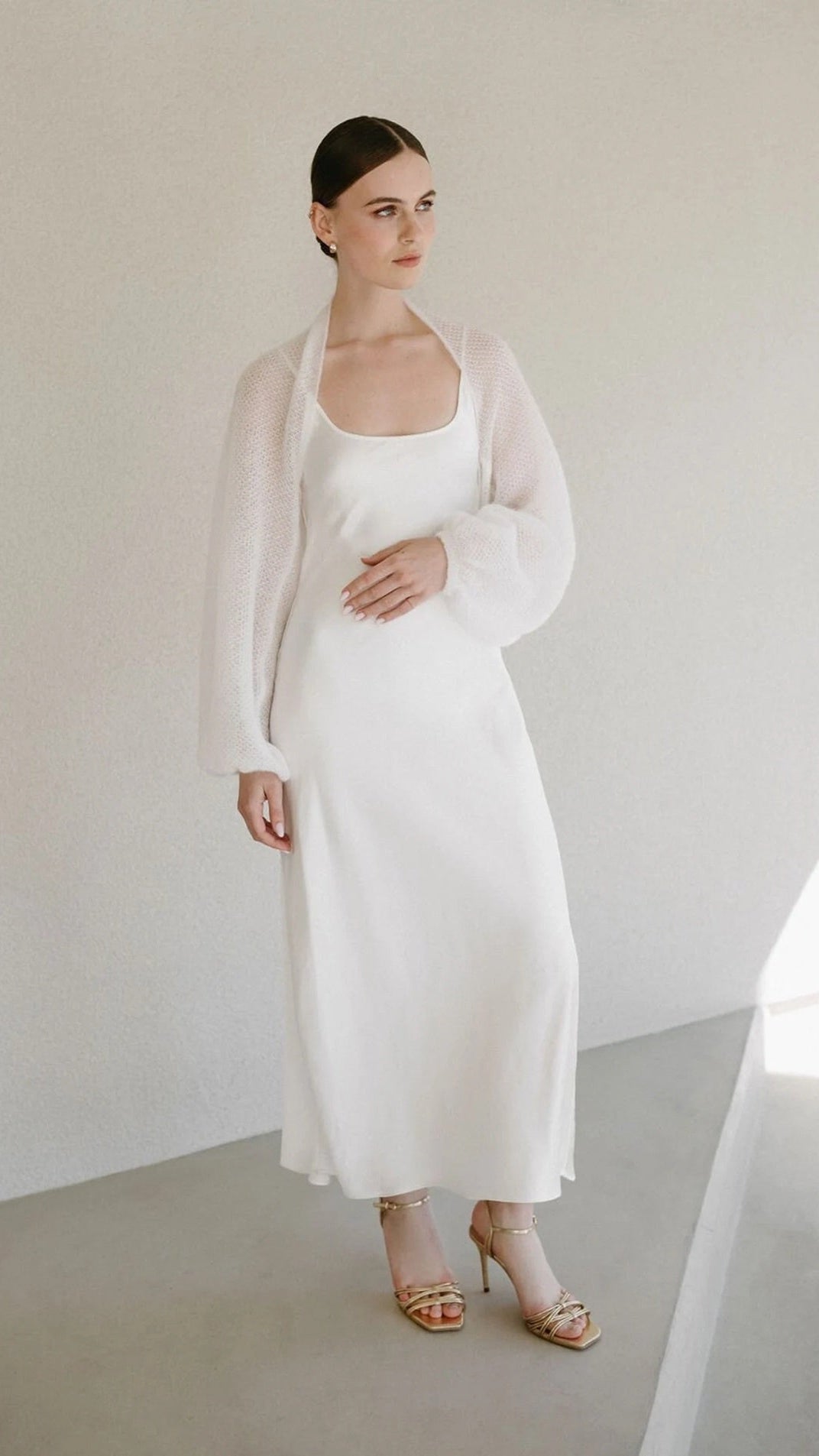 Woman wearing a white mohair bolero in fine knit.