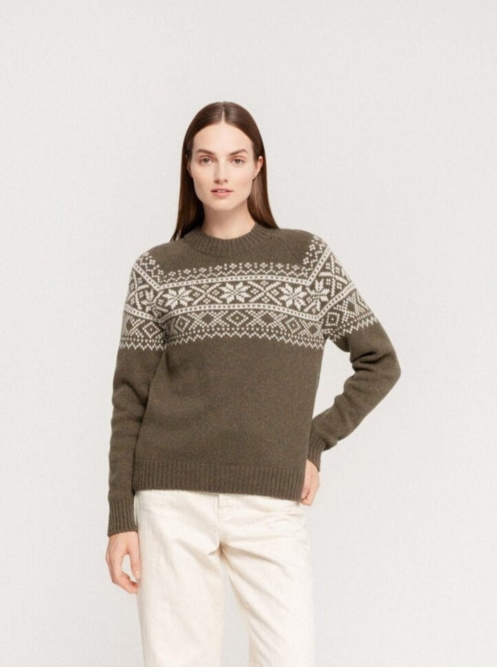 Woman wearing olive green sweater with white Nordic pattern and light linen pants