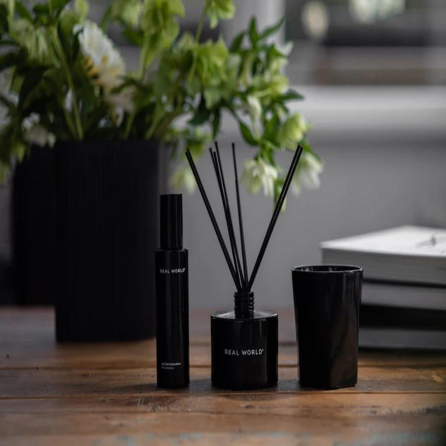 diffuser room spray and candle on wooden table