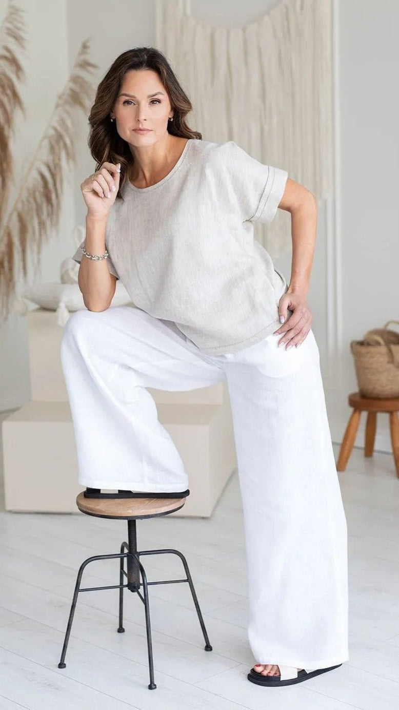 model wearing white linen short sleeve top standing