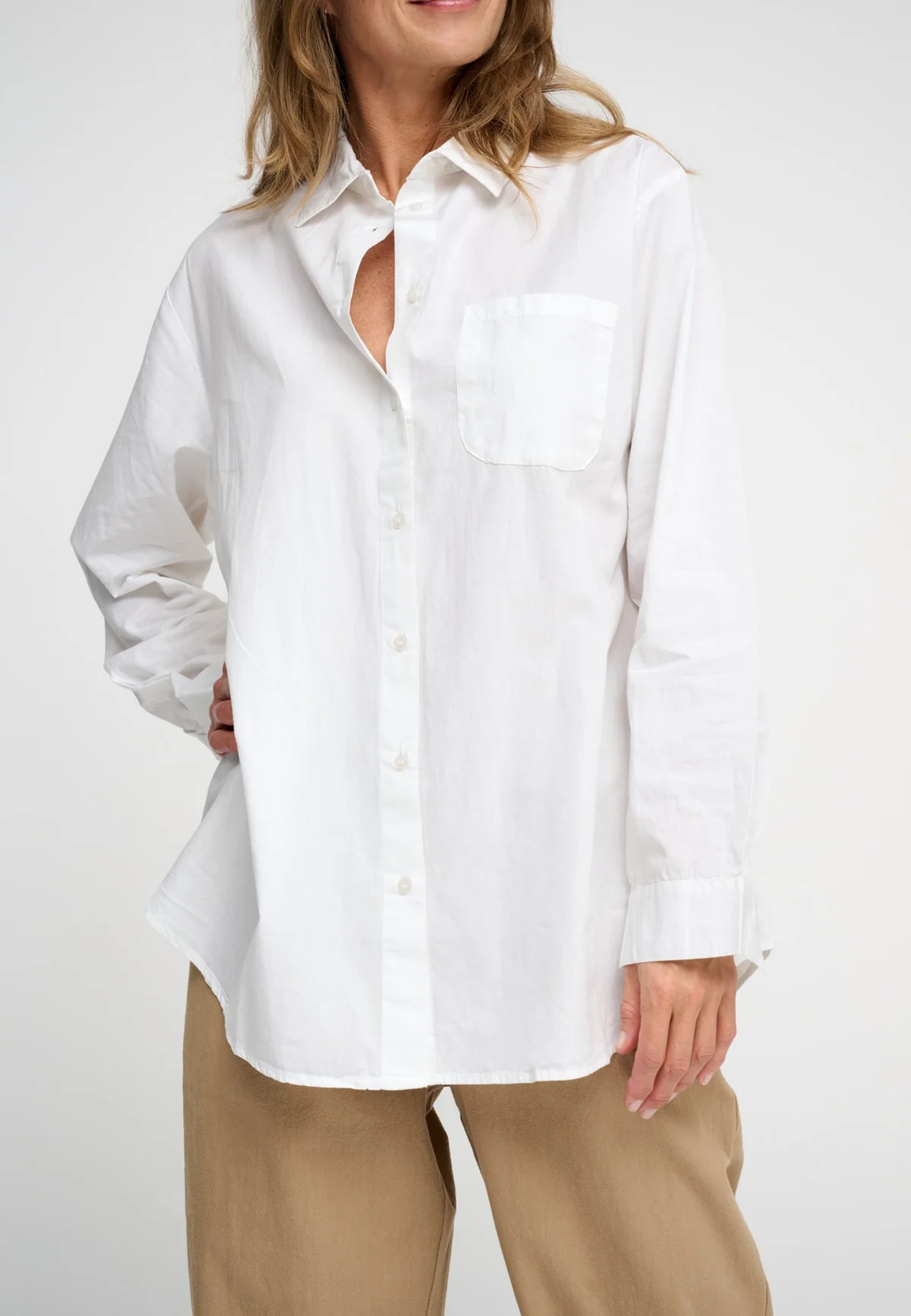 Woman wearing white button front poplin shit front view.