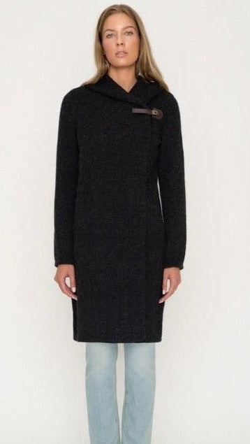 Woman wearing a black hooded cardigan sweater with toggle closure and light blue jeans