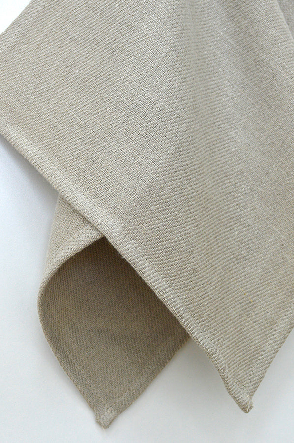 Beige linen napkin with textured weave on a light background
