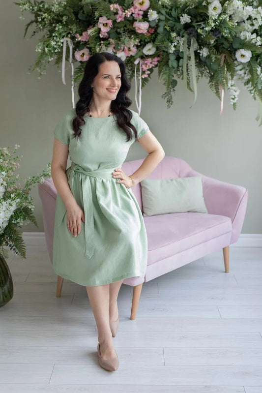 Model wearing Amy linen mint green dress with  belt & seated