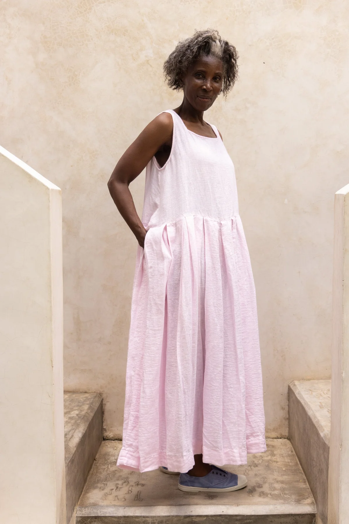 Woman wearing pink sundress side view.