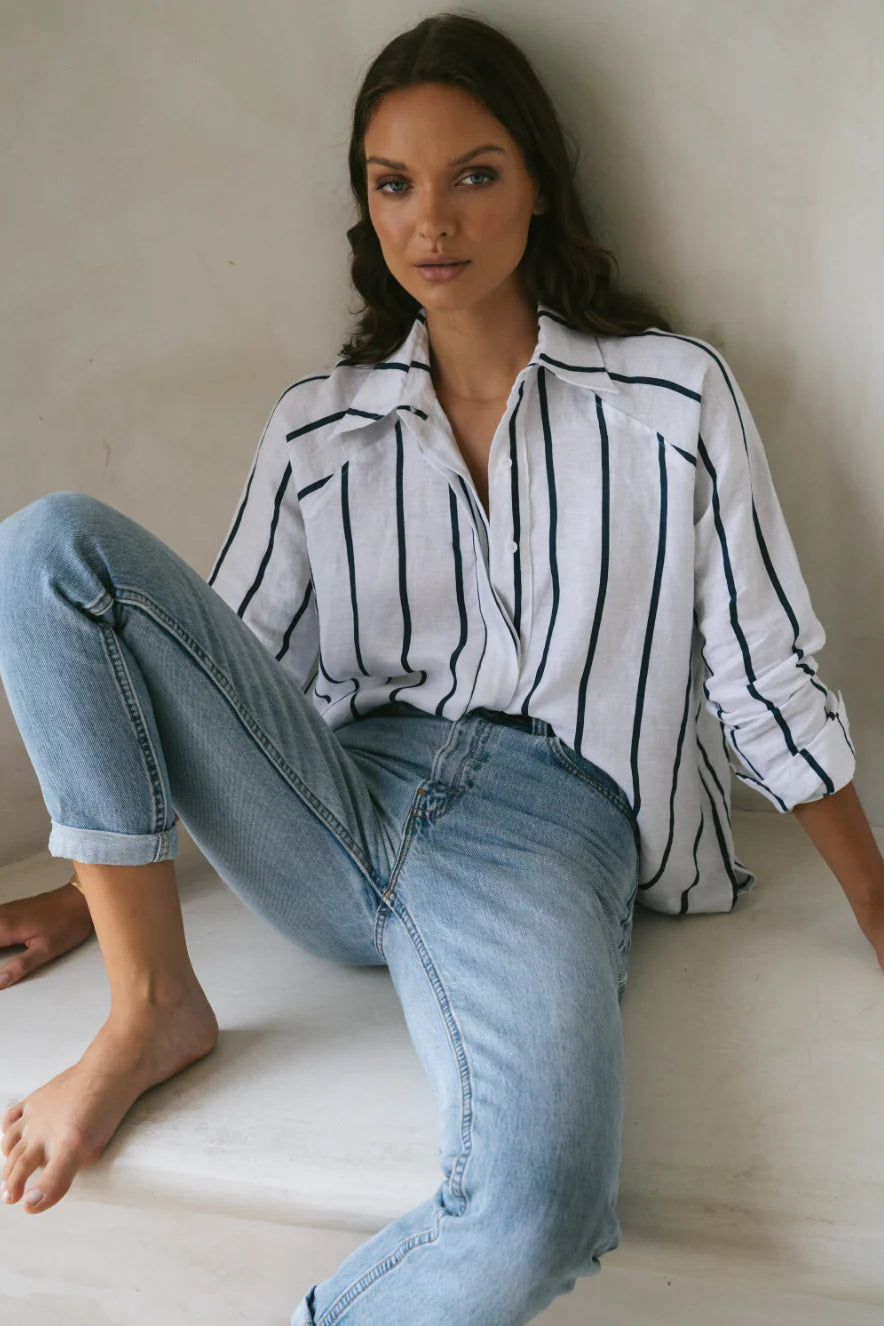 Woman wearing oversized shirt with wide stripe in navy and white featuring raglan sleeve