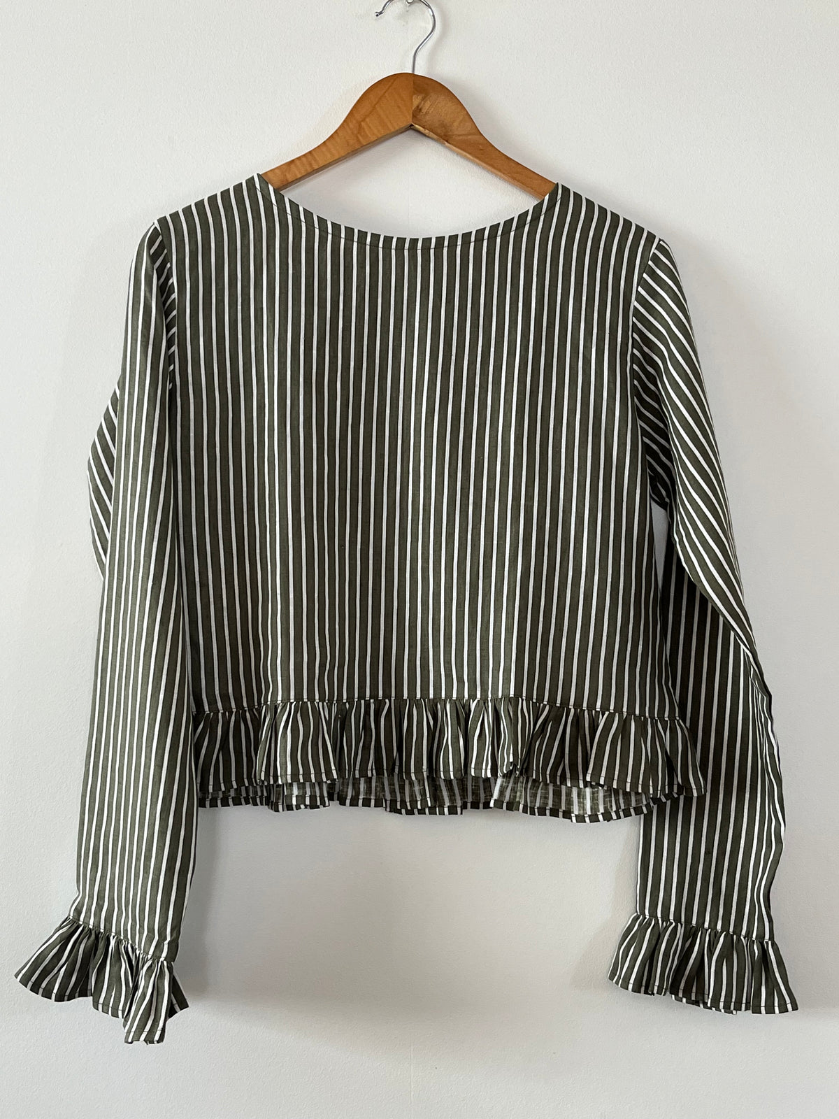 Cropped linen shirt with fill around hem and end of sleeves in green linen stripe.