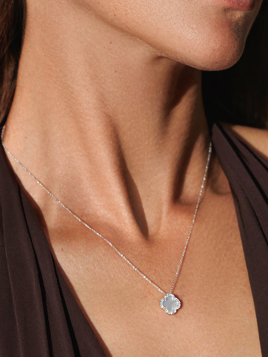Woman wearing a white shell fine flower necklace.