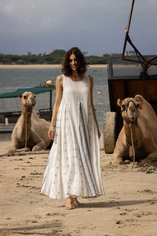 Woman wearing linen sleeveless A-Line dress with inverted back and front pleat with a contrasting print linen.