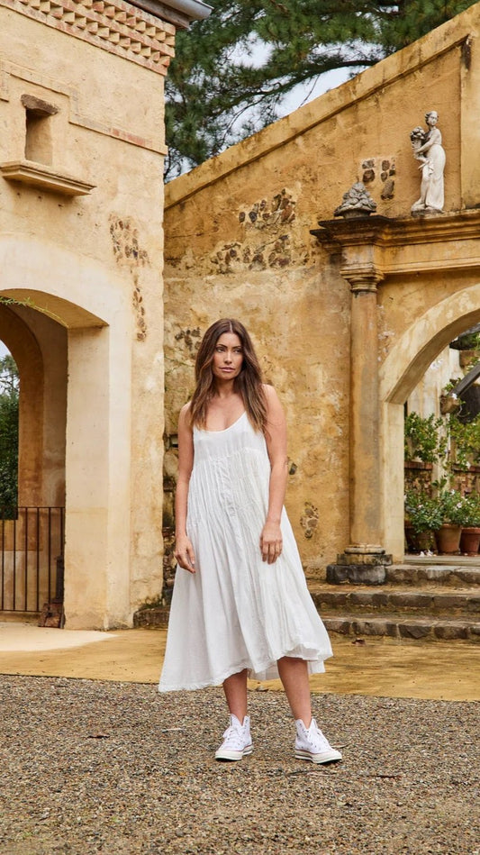 Woman wearing cotton silk slip dress in off white.