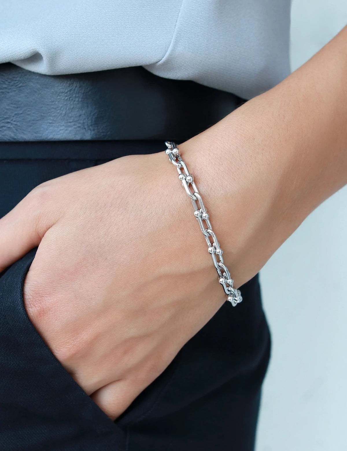 Woman wearing a rhodium plate link bracelet.