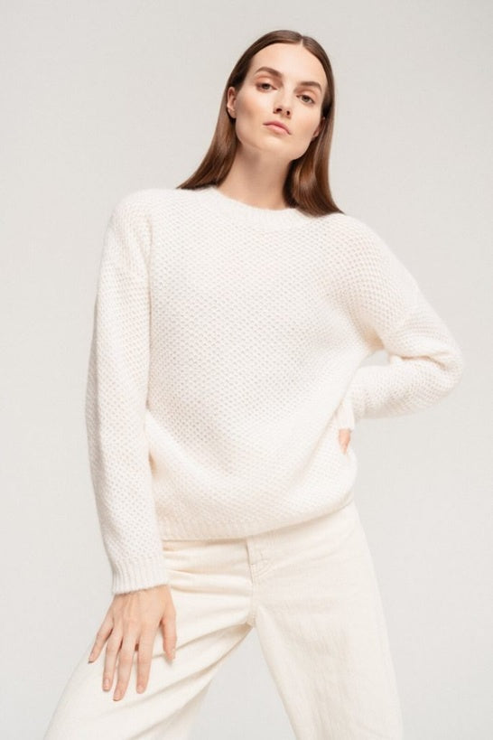 Delicate honeycomb pattern sweater is light and soft in white .