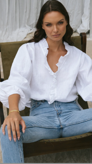 Woman wearing white linen ruffle neck shirt