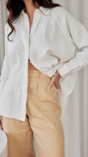 Model wearing cream linen shirt close up view of the button up front and raglan sleeve