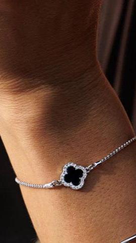 Woman's wrist wearing black flower bracelet in rhodium.