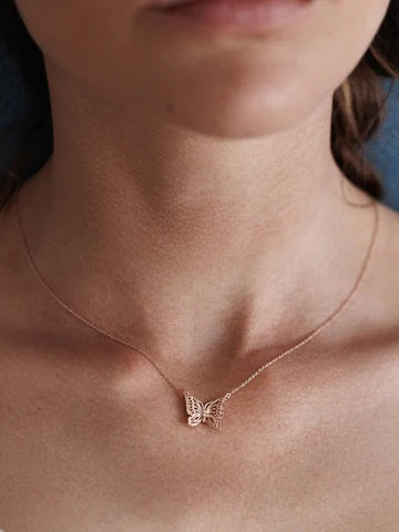 Woman wearing delicate rose gold plated butterfly necklace.