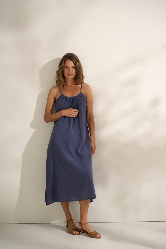 woman wearing blue pleated sun dress in gauze.
