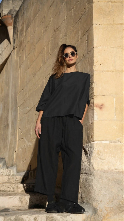 Woman wearing wide leg black cotton canvas pant with elastic tie waist.