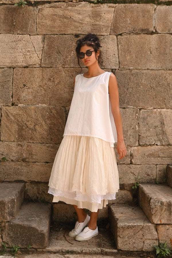Woman wearing oversize sleeveless paper cotton top in white.