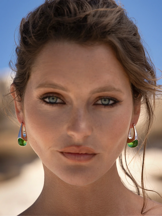 woman wearing rose gold loop earring with green glass finish.