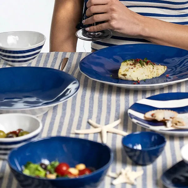 Striped linen tablecloth with blue and white tableware, seafood, and salad, summer dining setting