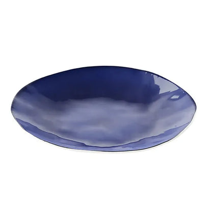 Deep blue ceramic dinner plate with glossy finish on a white background