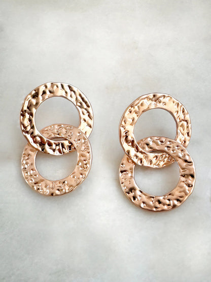 Hammered gold-tone double circle earrings on a white background