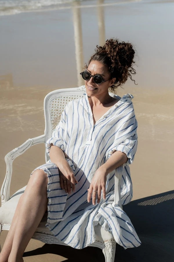 Woman wearing oversize blue & white stripe linen overshirt.