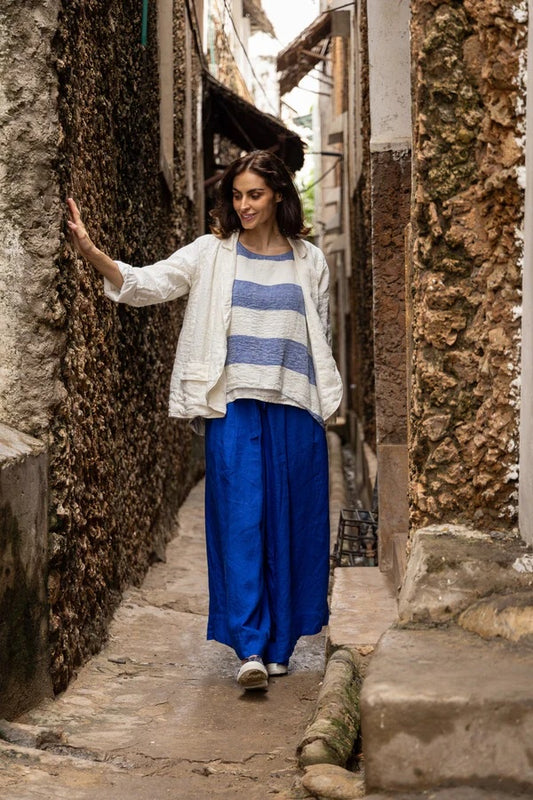Woman wearing wide leg cobalt blue linen pants with tie belt.