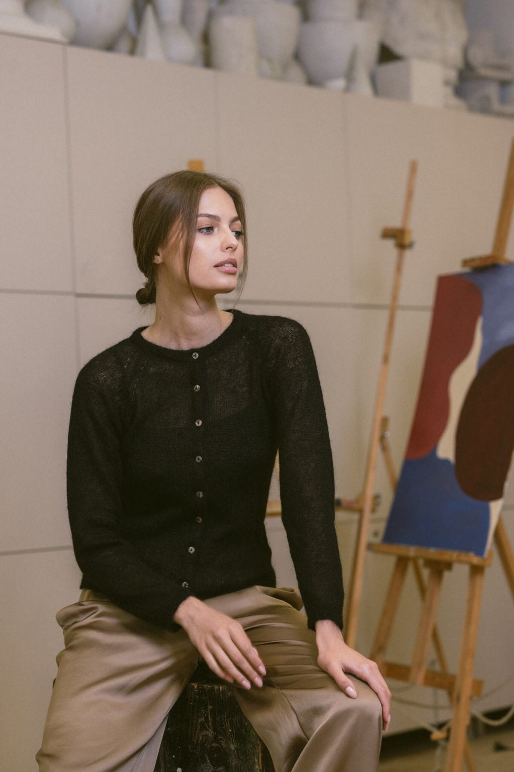 Woman wearing a fine knit black mohair cardigan with elegant buttons.