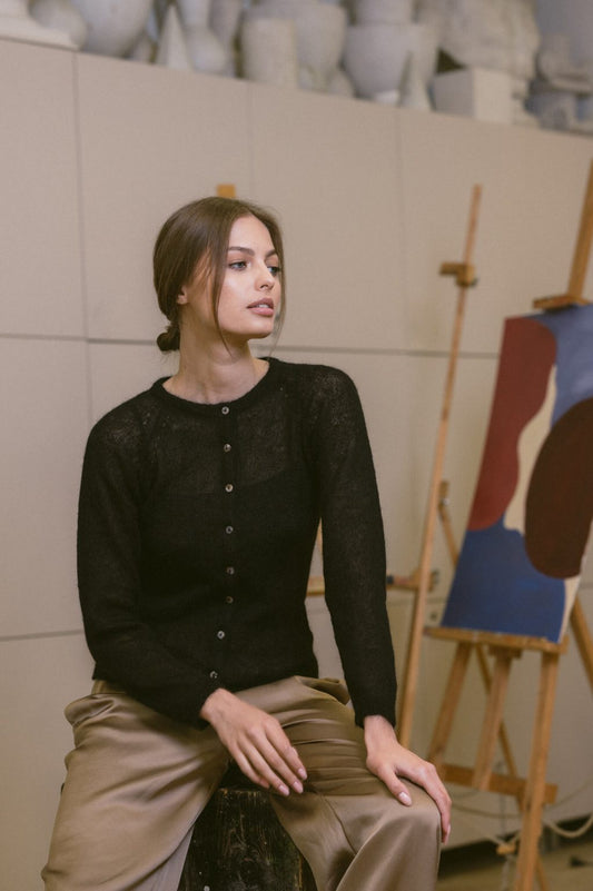 Woman wearing a fine knit black mohair cardigan with elegant buttons.